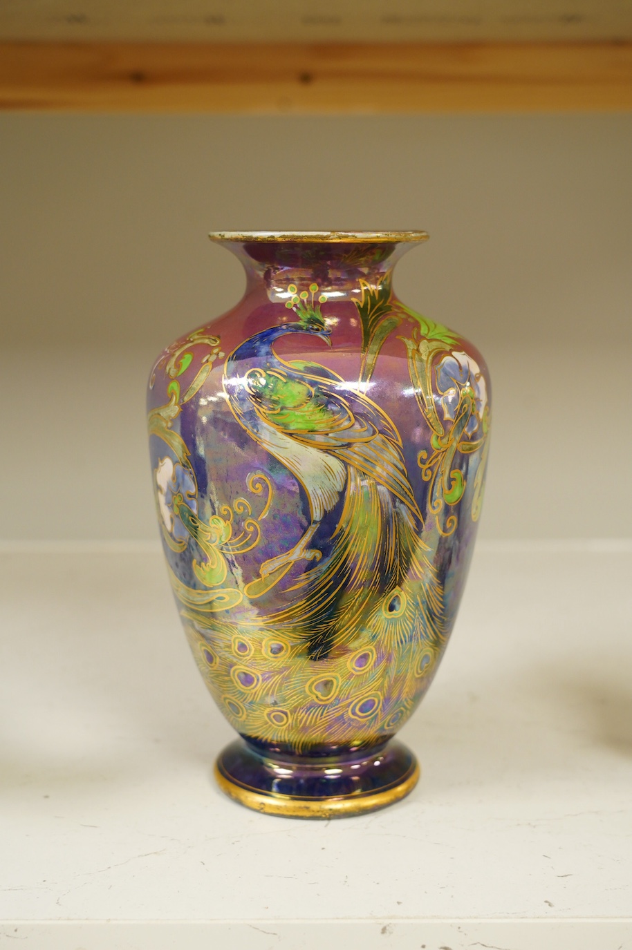 A Shelley Walter Slater pink and blue lustre peacock design vase, signed, 22cm high. Condition - fair to good, some wear to the gilt on the rim